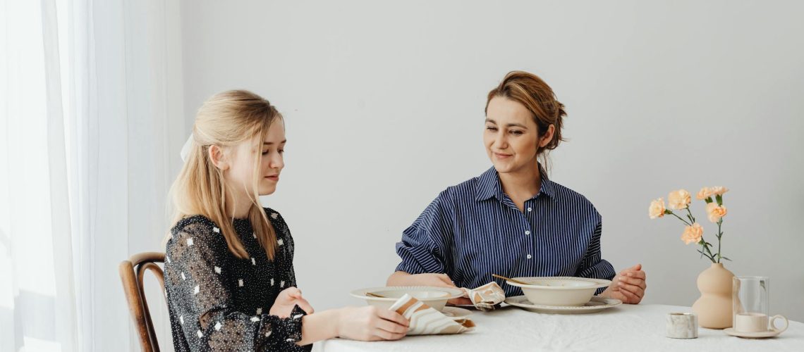 Mother and teenage daughter sharing a meal at the family dining table, the usual setting for the multidisciplinary treatment of eating disorders